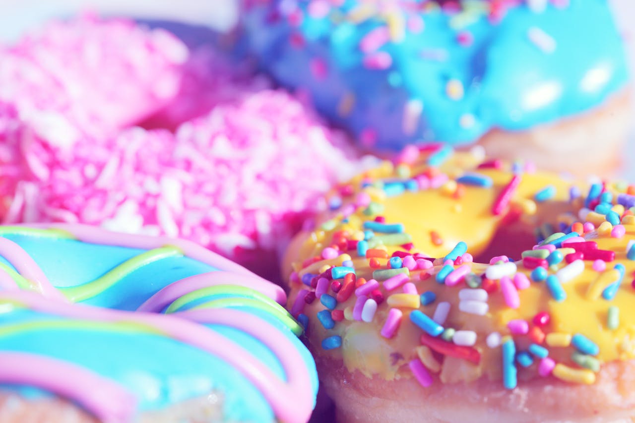 Home Close-up of assorted donuts with colorful icing and sprinkles, showcasing sweet indulgence.