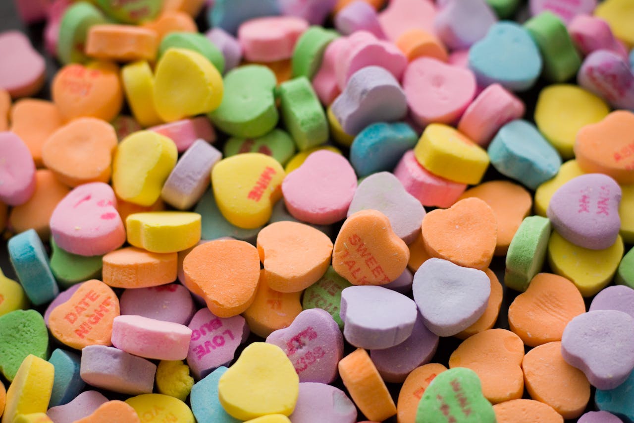 Home A vibrant collection of colorful, heart-shaped candies with printed phrases.