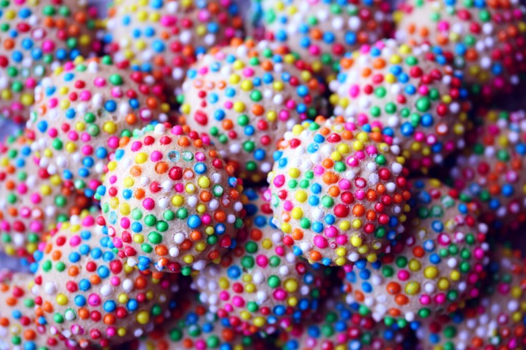 Close-up of colorful candies covered with festive round sprinkles.