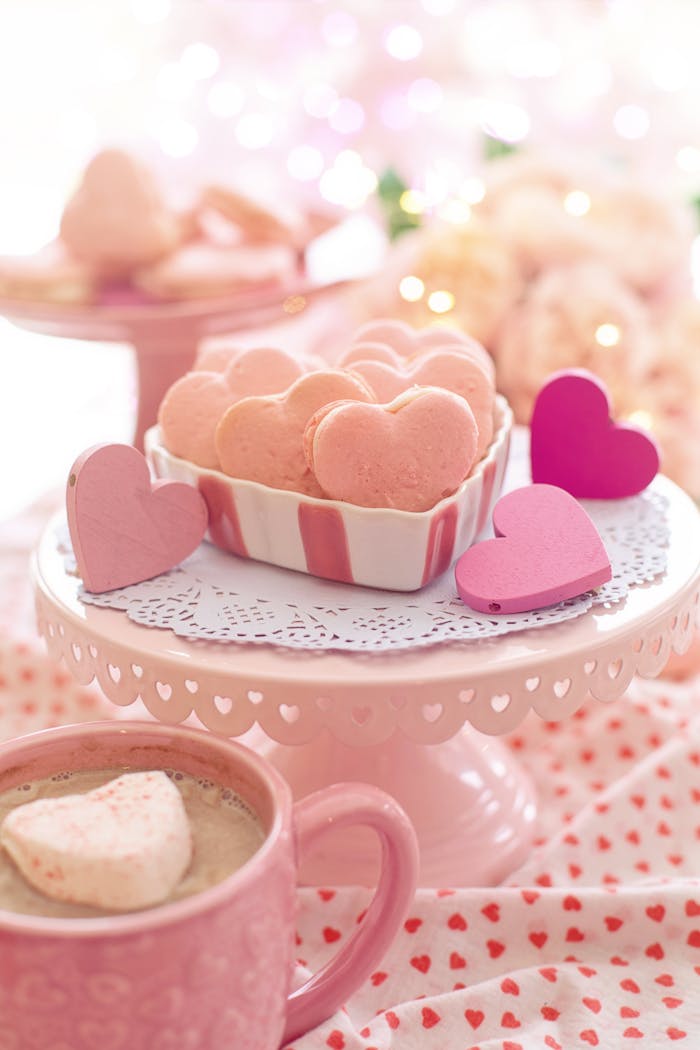 Indulge in heart-shaped pink macarons on a romantic Valentine's Day setting.